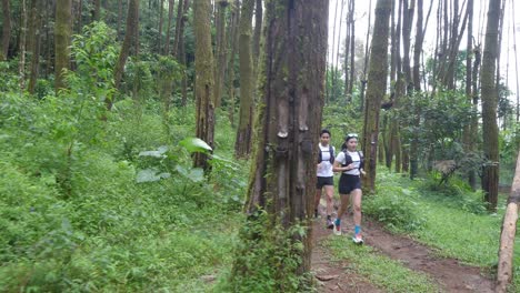 couple trail running in the forest