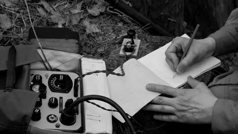 russian soviet infantry red army soldier in world war ii using russian soviet portable radio transceiver in trench entrenchment in spring autumn forest. 4k. headphones and telegraph key. close up hands, black and white colors