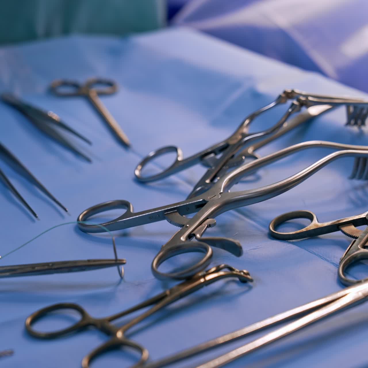A set of medical tools prepared for the operation. Instruments used at surgery on blue backdrop. Close up
