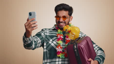 Traveler blogger tourist indian man in sunglasses taking selfie on smartphone record make video call