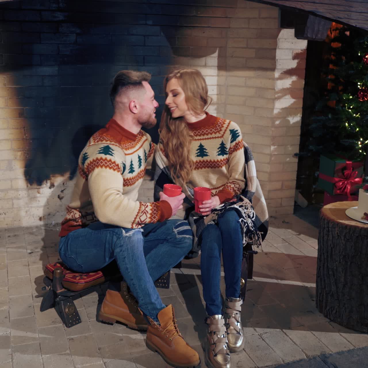 Young couple warming near fireplace in the evening. Romantic atmosphere before winter holidays
