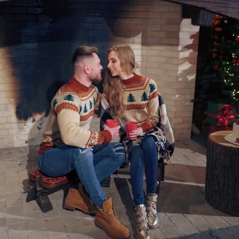 young couple warming near fireplace in the evening. romantic atmosphere before winter holidays