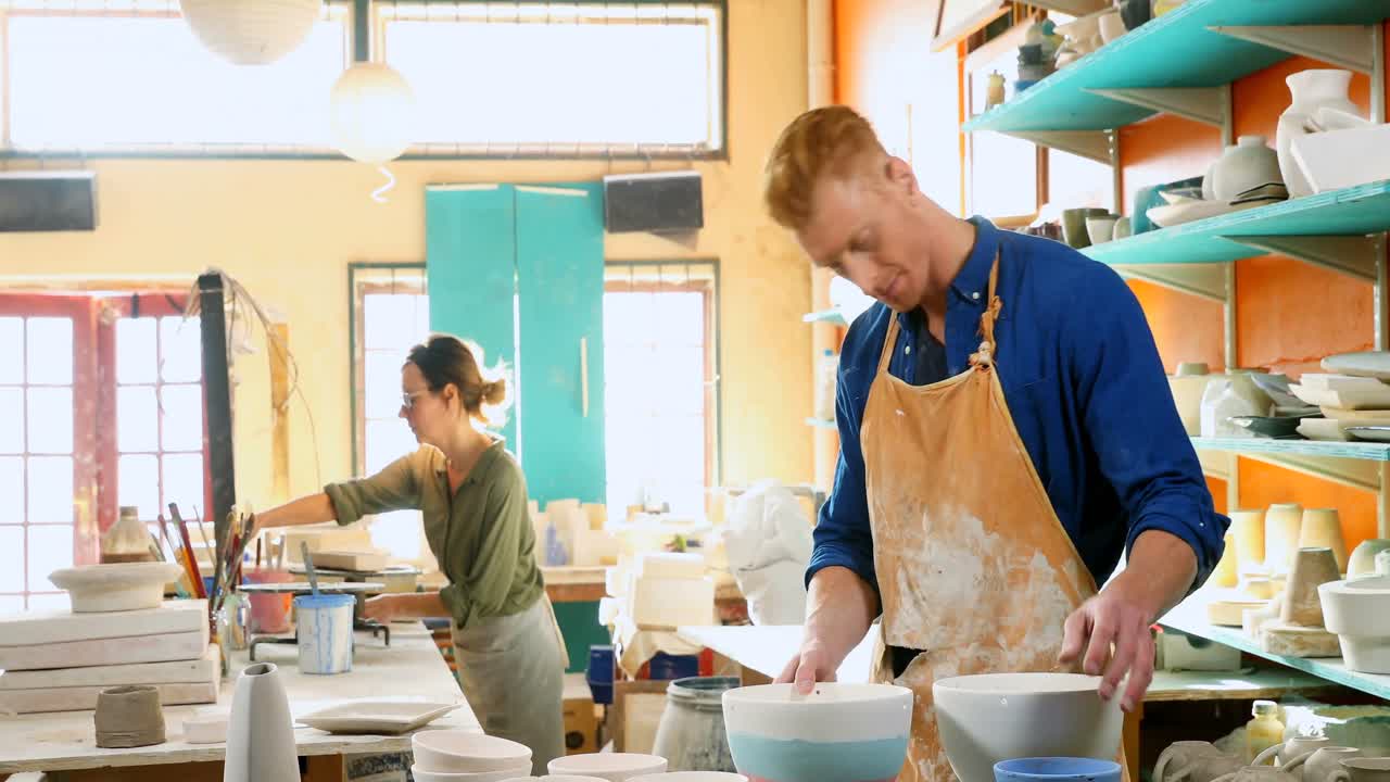 Male and female potter checking plate 4k