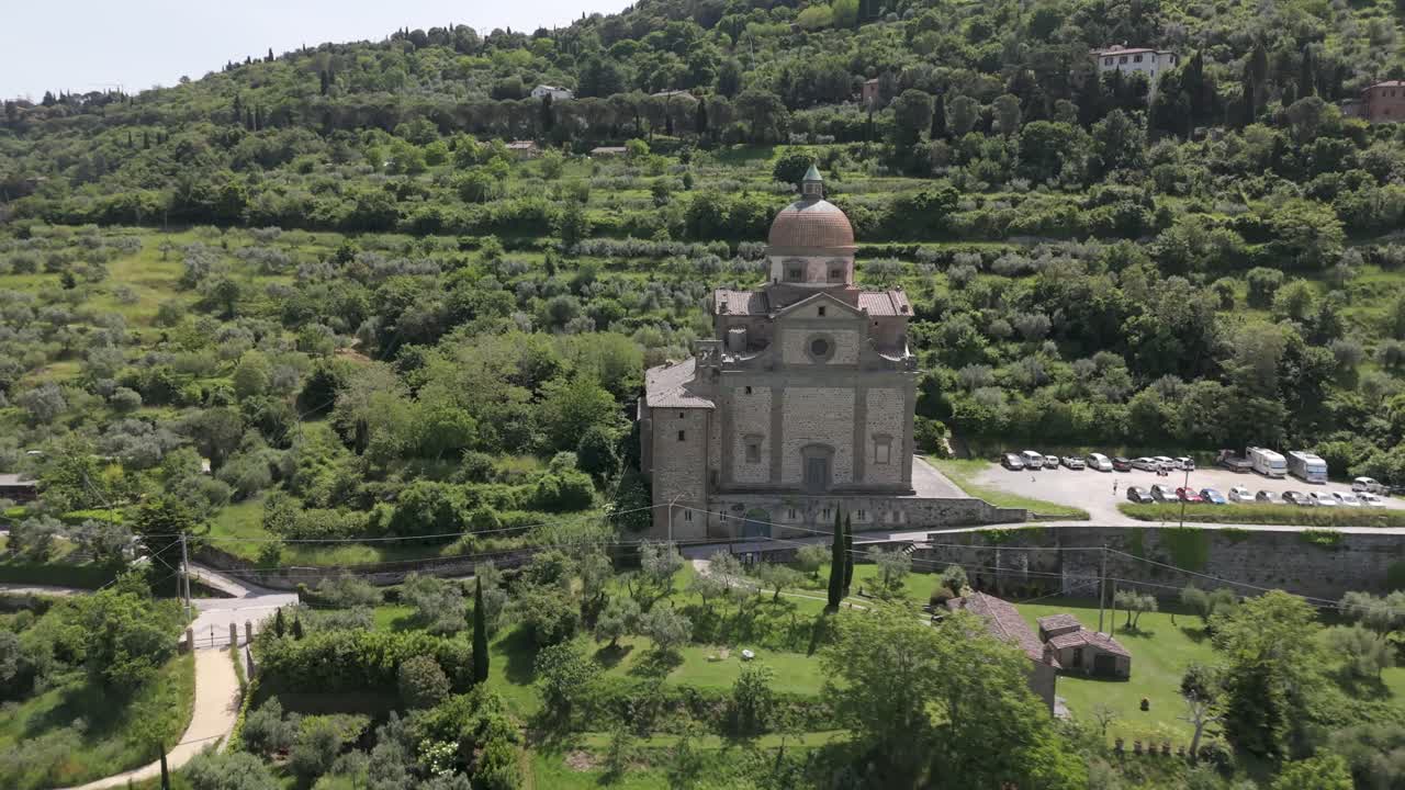 Idyllic Italian scene, lush green rolling hills of Cortona, Tuscany and church of Santa Maria Nuova, aerial view