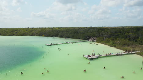 Tiefflug-über-Der-Wasseroberfläche-Des-Sees.-Menschen,-Die-Einen-Sonnigen-Tag-In-Einem-Erstaunlichen-Tropischen-Naturschwimmbad-Genießen.-Kaan-Luum-Lagune,-Tulum,-Yucatan,-Mexiko