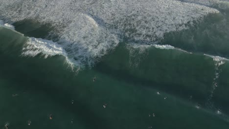 Aerial-views-over-surfers-at-Burleigh-Heads-at-sunrise,-Gold-Coast,-Queensland,-Australia