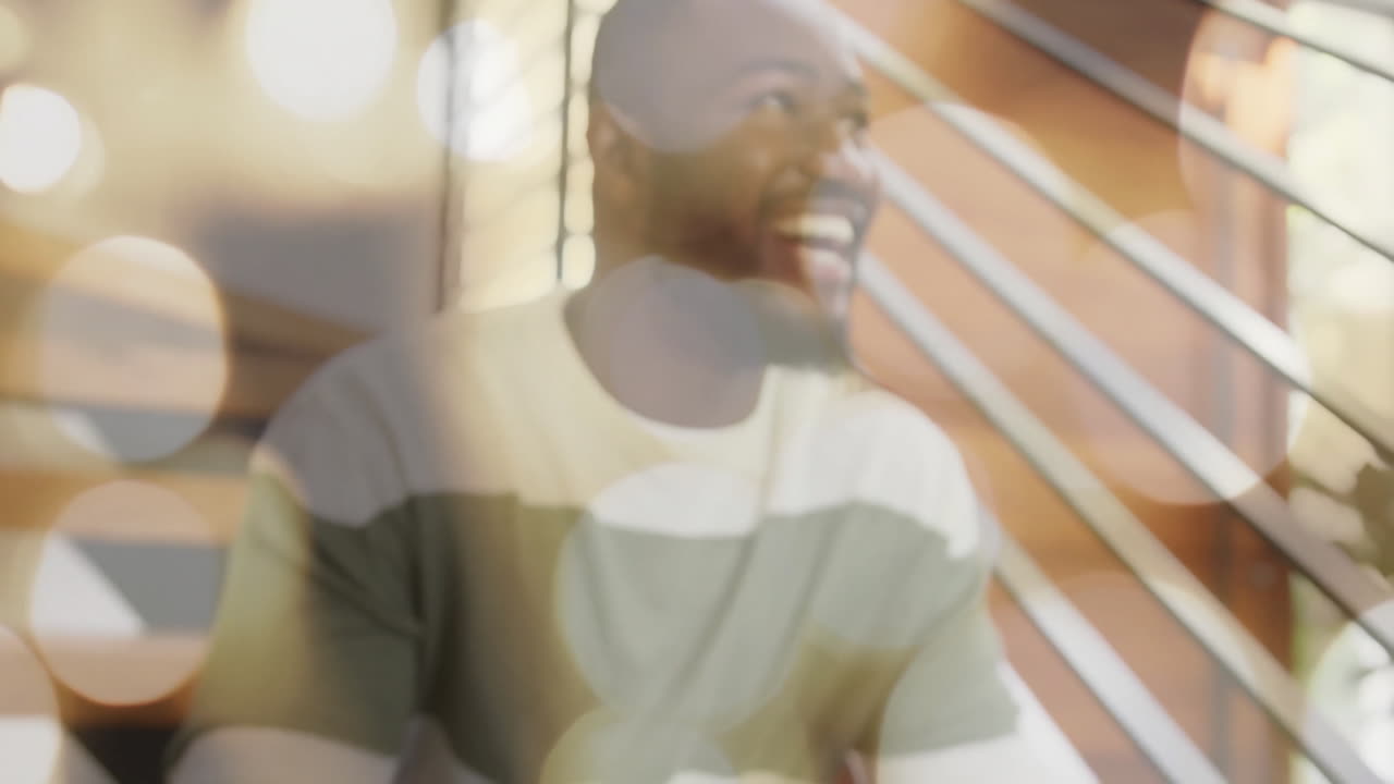 Smiling man with bokeh light animation over modern interior background