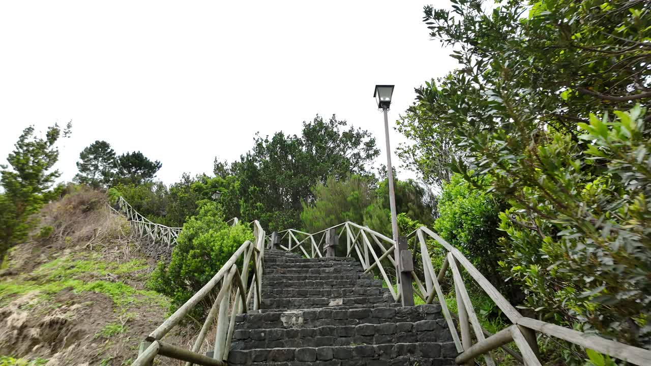 Pov of climbing stone stairs with wooden handrail in Sao Vicente, Madeira island, Portugal