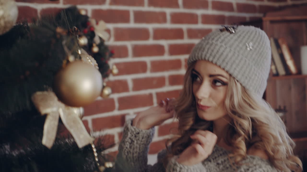 Woman preparig for Christmas Holiday. The girl decorates the Christmas tree for the holiday