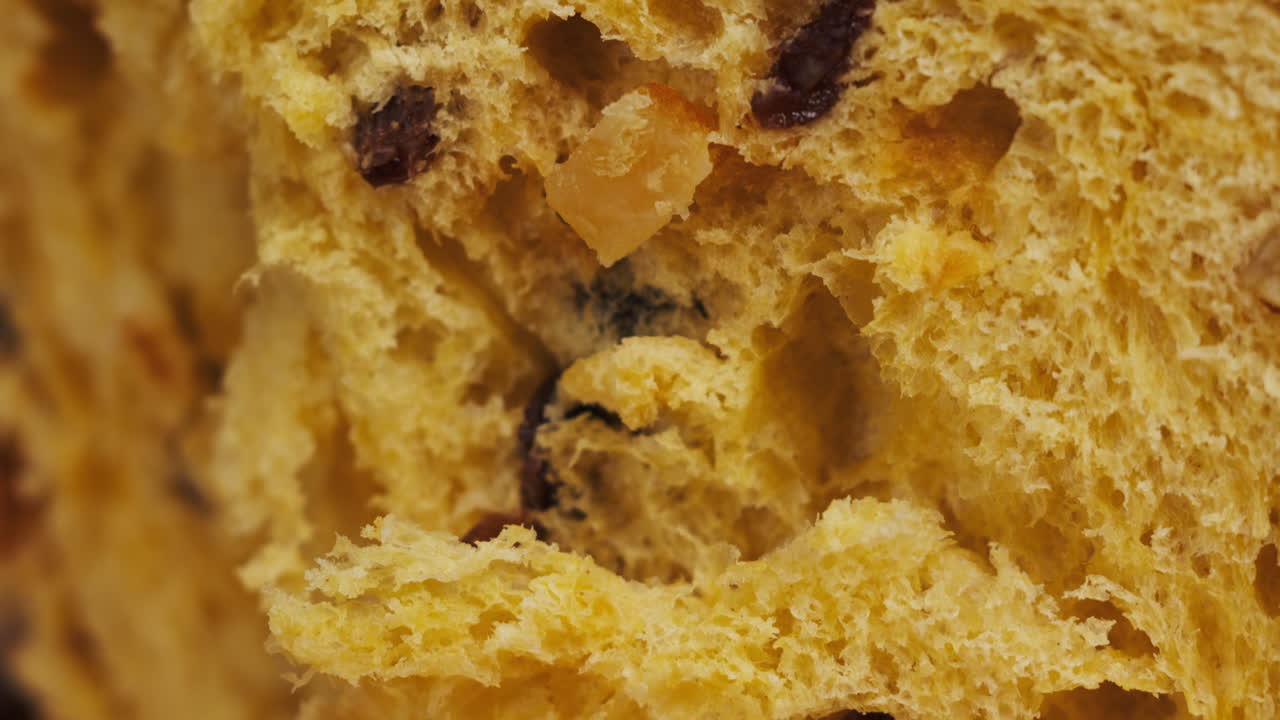 Traditional English Christmas cake tied with a jute thread on the black background. Italian classic Panettone .Pastry Chef sprinkles powdered sugar through a sieve on the fruit Easter cake with raisins. High quality 4k footage