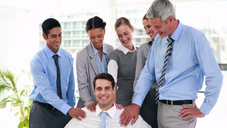 personas de negocios sonriendo a su compañero de trabajo en silla de ruedas