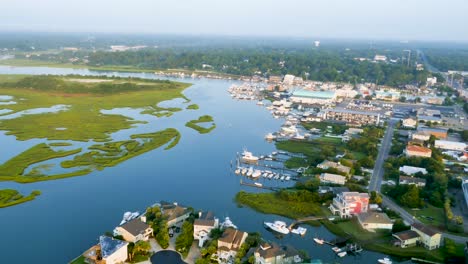 4k view of blue and green marsh rotating to reveal small beach town from above