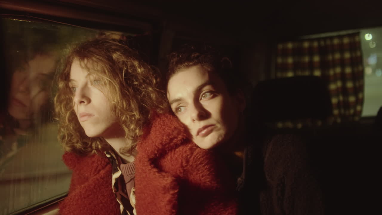 Girlfriends Cuddling during Car Ride at Night