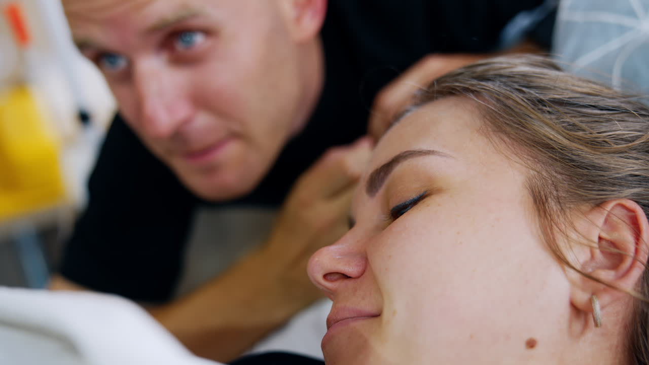 Happy faces of parents looking at their newborn. Close up portraits of new-made mom and dad.
