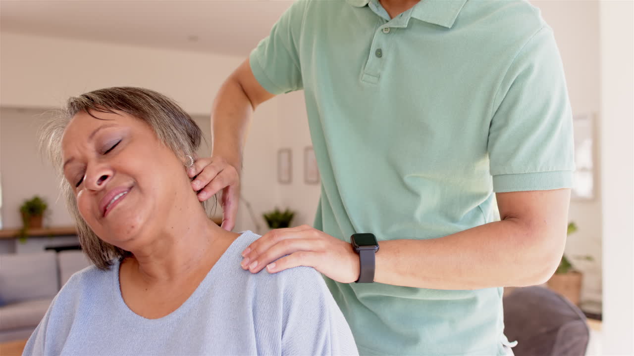 Physiotherapist massaging senior woman's neck and shoulder for pain relief