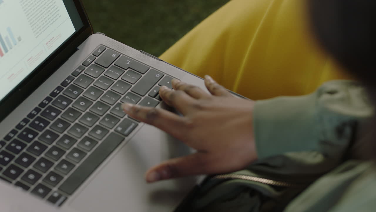 manos cerradas mujer de negocios afroamericana usando computadora portátil digital navegando por estadísticas de marketing viendo datos de desarrollo de crecimiento financiero en la pantalla trabajando en un proyecto de investigación en la oficina