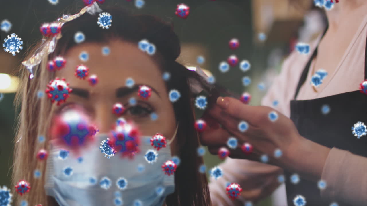 animación de células de coronavirus sobre una peluquera caucásica y una mujer que usa máscaras faciales