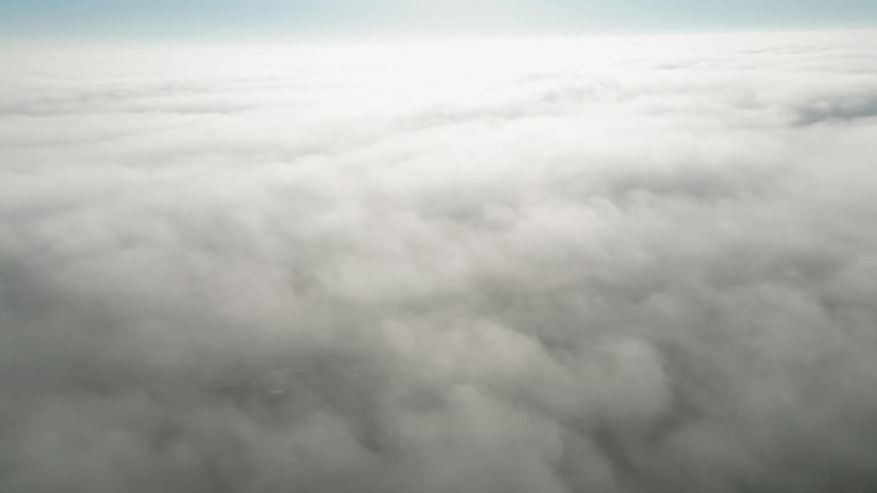 Heavenly drone footage over the top of a thick layer of fog