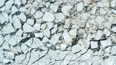 aerial fly over view of cracked ice floes floating in the sea