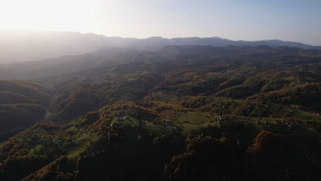 Pestera-Dorf-In-Brasov-Bei-Sonnenuntergang-Mit-Sanften-Hügeln-Und-Verstreuten-Häusern,-Luftaufnahme