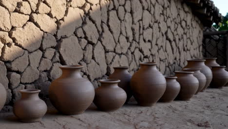 handmade clay pots by a stone wall