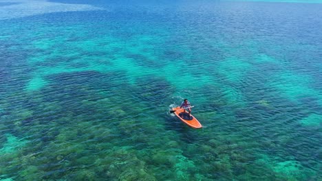 man paddling on the shore of tagbak marine park with a view of the coral reef underwater in southern leyte