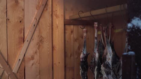 closeup of roe deer meat hanging inside smokehouse shed in norway