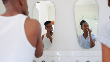 Couple,-together-and-brushing-teeth-in-mirror