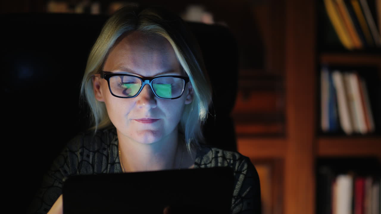 mujer con tableta en estudio por la noche