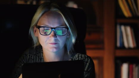 mujer con tableta en estudio por la noche