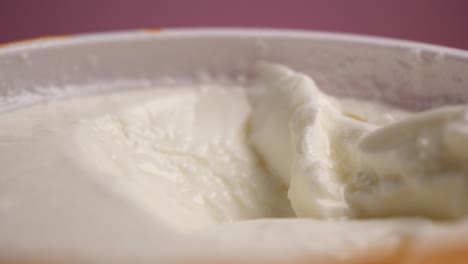 close up of yogurt in a bowl with spoon