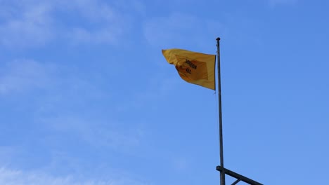 bandera amarilla ondeando contra el cielo azul