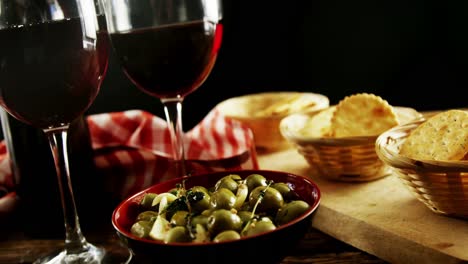 vino tinto servido con tapas de aceituna y galletas