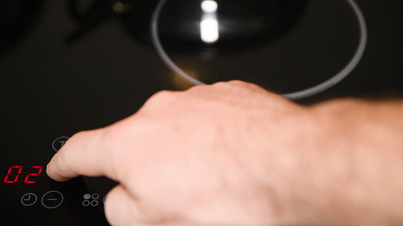 전기 스토브 컨트롤 패널 닫기, 수컷 손가락 누르기 버튼, 빨간색 led 표시등 켜짐, 수컷 손가락 켜기 타이머