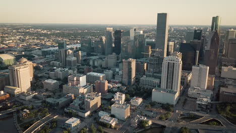 peaceful aerial parallax shot of downtown houston area at sun set. twilight drone view of the city of houston, with tall buildings and horizon, and empty streets. wide shoot