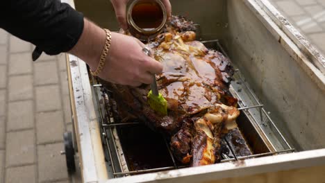 Hombre-Usando-Glaseado-Con-Miel-En-Una-Enorme-Carne-De-Bestia-Asada-Lentamente