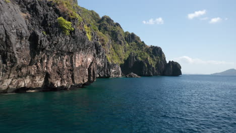 Drohnenaufnahme-über-Wasser-Mit-Klippen-Und-Felsen-Auf-Der-Insel-Matinloc,-El-Nido,-Palawan,-Philippinen