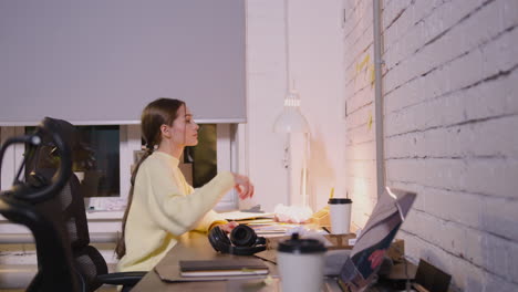 female employee writing something on paper and then taking adhesive note from wall in office