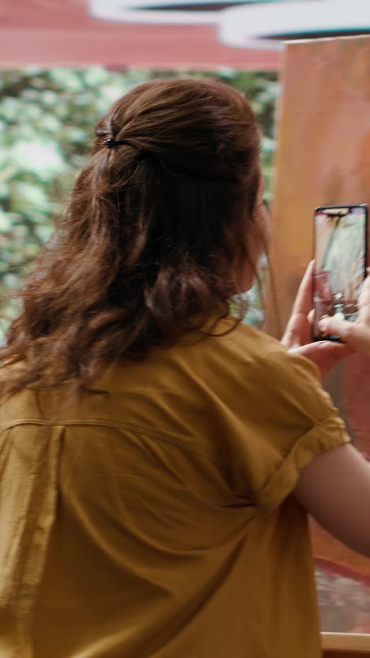 Artista donna che scatta una foto del suo dipinto con lo smartphone