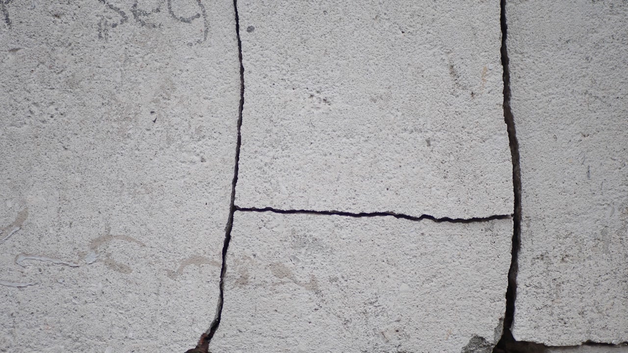 Close-up of a Damaged Gray Concrete Surface with Cracks
