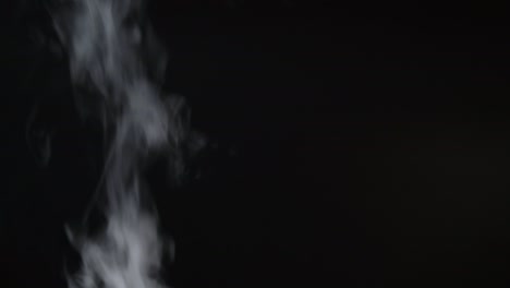 el humo blanco, la niebla, la neblina, el vapor sobre un fondo negro. imágenes en 4k.