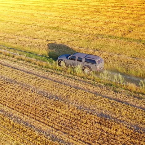 car in field on country road