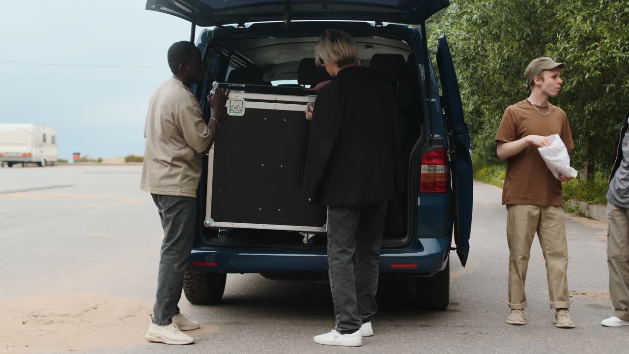 록 밴드 멤버들이 야외에서 이야기하고 있습니다.