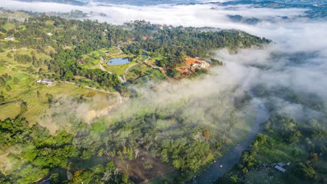 sunrise in jarabacoa over the river yaque del norte with low clouds, stunning caribbean weather in the dominican republic, with trees, vegetation and a small lake surrounded by nature