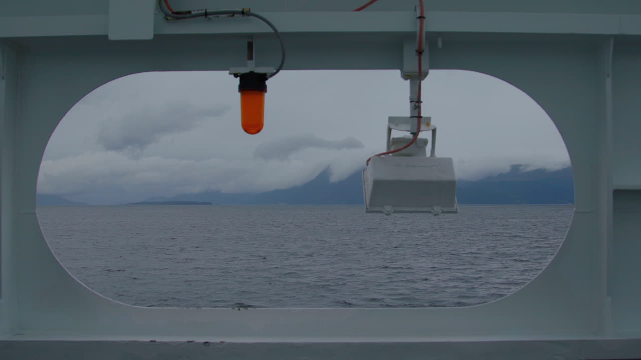A distant shore covered with cloudes viewed from the ferry