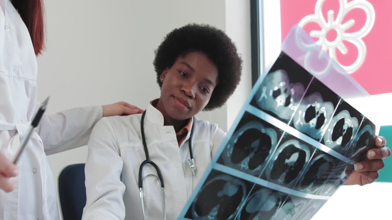 Medical workers discuss the xray photograph two female specialists in medical uniform examining xray