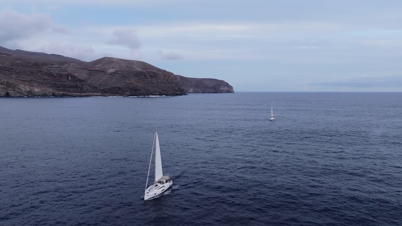drones de yates que se deslizan a través del océano atlántico, acantilados dramáticos, la gomera, 4k