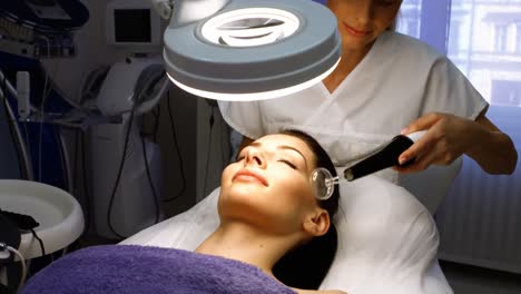 Doctor-performing-laser-hair-removal-on-patient