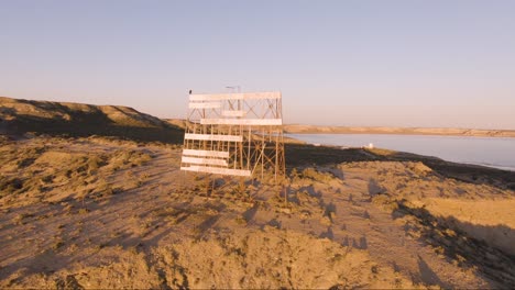 View-Of-An-Old-Beacon-Signal-In-Peninsula-Valdes,-Patagonia,-Argentina---wide-aerial,-orbiting-shot