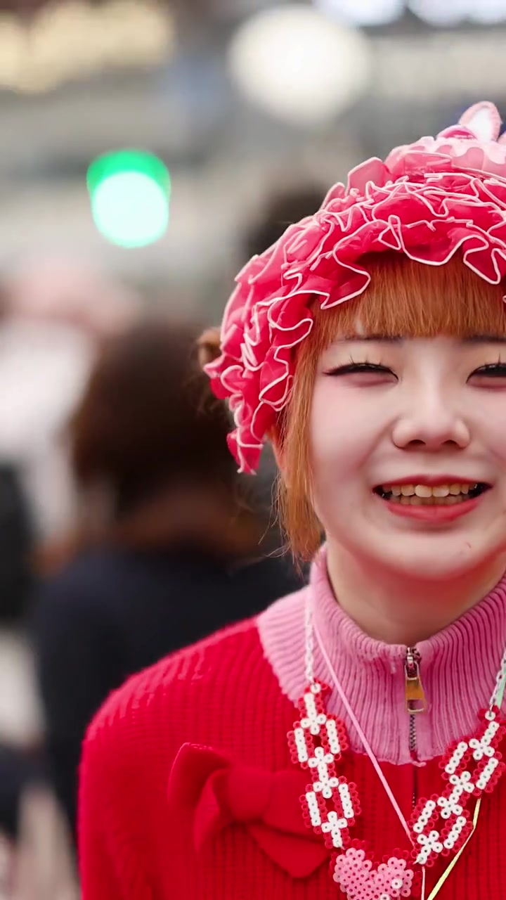 Una giovane donna in vivace stile street decora rosso ride ad Harajuku, Tokyo, Giappone